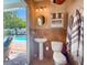 Bathroom near pool offering a pedestal sink and adjacent outdoor access at 409 Erie Ave, Tampa, FL 33606