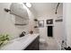 Stylish bathroom features a round mirror, patterned floor, and a tub/shower with tiled walls at 409 Erie Ave, Tampa, FL 33606