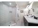 Modern bathroom with a glass shower, subway tile, and double sinks with black accents at 409 Erie Ave, Tampa, FL 33606