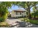 Charming home featuring a welcoming front porch, manicured lawn, and mature trees at 409 Erie Ave, Tampa, FL 33606