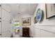 Hallway with paneled walls, neutral-toned floor, with a glimpse of the pool at 409 Erie Ave, Tampa, FL 33606