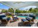 Relaxing covered patio with wicker furniture overlooking a pool and lush landscaping at 409 Erie Ave, Tampa, FL 33606