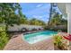 Sparkling pool with brick pavers and serene backyard featuring mature trees at 409 Erie Ave, Tampa, FL 33606