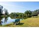 Scenic view of community pond with bench, palm trees, and lush landscaping at 4215 E Bay Dr # 1808D, Clearwater, FL 33764