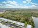 An aerial view showing single-story residences near a river with a backdrop of lush green trees and a blue sky at 4235 Richmere Dr # 4235, New Port Richey, FL 34652