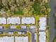 Overhead view of a tidy neighborhood with single-story residences beside a waterway, showcasing mature landscaping at 4235 Richmere Dr # 4235, New Port Richey, FL 34652