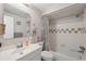 Clean bathroom featuring a sink and a shower-tub combo with tiled walls and a patterned shower curtain at 4235 Richmere Dr # 4235, New Port Richey, FL 34652
