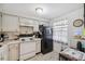 Bright kitchen featuring white cabinets, white appliances, and a black refrigerator at 4235 Richmere Dr # 4235, New Port Richey, FL 34652