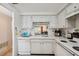 White kitchen with stainless steel faucet and white appliances, including a dishwasher at 4235 Richmere Dr # 4235, New Port Richey, FL 34652