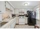Bright kitchen with white cabinets and tile backsplash, featuring a black refrigerator at 4235 Richmere Dr # 4235, New Port Richey, FL 34652