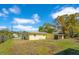 Rear view of the home's yellow exterior with a well-sized backyard and partial fencing at 4509 26Th S Ave, Tampa, FL 33619