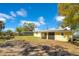 Exterior view of the yellow house with a covered porch and a large backyard at 4509 26Th S Ave, Tampa, FL 33619