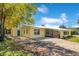 A charming yellow home featuring a new metal roof, bright blue front door, and spacious driveway at 4509 26Th S Ave, Tampa, FL 33619