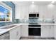 Updated kitchen with white cabinets, stainless steel appliances, and stylish backsplash at 4509 26Th S Ave, Tampa, FL 33619