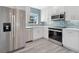 Well-appointed kitchen with stainless steel appliances, white cabinetry, and a modern backsplash at 4509 26Th S Ave, Tampa, FL 33619