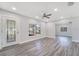 Bright living room featuring new gray wood floors, neutral paint, and a ceiling fan at 4509 26Th S Ave, Tampa, FL 33619