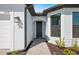 Close-up of the home's entrance featuring a dark front door and manicured landscaping at 4597 Blue Star Ct, North Port, FL 34289