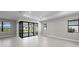 Spacious living room with tiled floors, neutral paint, and sliding doors to the screened patio at 4597 Blue Star Ct, North Port, FL 34289