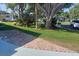 Expansive yard with mature trees, lush greenery, and a brick walkway at 46 Washington Ct # 28, Palm Harbor, FL 34684