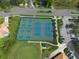 Overhead shot of well-maintained tennis courts and surrounding greenery in a landscaped community with parking at 4802 Raintree Street E Cir, Bradenton, FL 34203