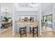 Kitchen bar with seating, offering a view to dining area and screened-in pool at 5232 Kirkwood Ave, Spring Hill, FL 34608
