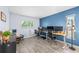 Home office featuring a bright blue accent wall, modern flooring, and multiple monitors at 5232 Kirkwood Ave, Spring Hill, FL 34608
