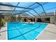 Inviting screened-in pool area with comfortable seating, lush greenery, and clear blue water at 5232 Kirkwood Ave, Spring Hill, FL 34608