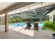 Inviting screened-in pool area with lounge chairs, mature landscaping, and a covered patio, perfect for relaxation at 5232 Kirkwood Ave, Spring Hill, FL 34608