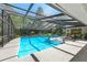 Relaxing screened-in pool area featuring lounge chairs, lush greenery, and plenty of sunshine at 5232 Kirkwood Ave, Spring Hill, FL 34608