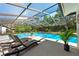 A refreshing screened-in pool area with lounge chairs and lush greenery, perfect for relaxation and leisure at 5232 Kirkwood Ave, Spring Hill, FL 34608