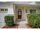 Inviting front entrance with a red door, manicured bushes, and a tiled walkway at 6019 Gannetdale Dr, Lithia, FL 33547