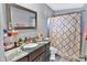 Well-lit bathroom featuring granite counters, vanity with sink, stylish mirror, and shower-tub combination at 6208 Florida W Cir, Apollo Beach, FL 33572