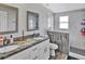 Bright bathroom featuring a double sink vanity with granite counters, tiled shower, and modern fixtures at 6208 Florida W Cir, Apollo Beach, FL 33572