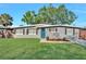 Charming single-story home featuring a well-manicured lawn and blue front door at 6208 Florida W Cir, Apollo Beach, FL 33572