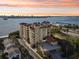 Aerial view of a multi-story waterfront building and harbor with sunset sky at 700 N Osceola Ave # 504, Clearwater, FL 33755