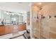 Bathroom featuring double sinks with wood cabinets, a walk-in shower with tile surround, and a soaking tub at 700 N Osceola Ave # 504, Clearwater, FL 33755