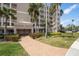 Beautiful exterior of a multi-story home with lush landscaping and palm trees on a sunny day at 7296 Marathon Dr # 406, Seminole, FL 33777