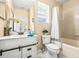 Bright bathroom showcasing a white vanity, decorative mirror, and tiled shower-tub combination at 10115 Courtney Palms Blvd # 202, Tampa, FL 33619