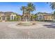 Beautiful community entrance with meticulously manicured landscaping, a circular driveway, and a central fountain at 10115 Courtney Palms Blvd # 202, Tampa, FL 33619
