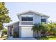 Charming two-story home featuring a white garage door, palm trees, and a well-maintained front yard at 11379 Brookgreen Dr, Tampa, FL 33624