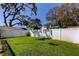 Spacious green backyard enclosed by a white fence, providing a private and secure outdoor area at 11492 60Th Lane, Pinellas Park, FL 33782