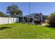 Well-maintained backyard featuring a screened patio, lush lawn, and white fence, creating a welcoming outdoor oasis at 11492 60Th Lane, Pinellas Park, FL 33782