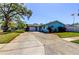 Brightly painted home with a long driveway, attached garage, and well-maintained landscaping at 11492 60Th Lane, Pinellas Park, FL 33782