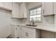 Updated kitchen with white cabinetry, granite countertops, and stainless steel sink at 11492 60Th Lane, Pinellas Park, FL 33782