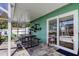 Covered patio featuring a picnic table, decorative plants, and sliding glass doors to the pool area at 11492 60Th Lane, Pinellas Park, FL 33782
