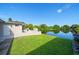 Lush backyard with green grass, a patio, and a beautiful lake view, perfect for relaxation at 1163 60Th S Ave, St Petersburg, FL 33705