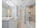 Bright bathroom featuring a shower with a built-in shelf and a vanity with double sinks at 1163 60Th S Ave, St Petersburg, FL 33705