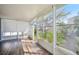 Bright sunroom with wood-look tile floors and walls of screened windows overlooking the backyard at 1217 Alhambra Crest Dr, Ruskin, FL 33570