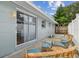 Backyard patio area with wicker furniture, blue cushions, a privacy fence, and a sliding glass door at 1260 S Hillcrest Ave, Clearwater, FL 33756