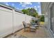 Backyard patio area with wicker furniture, blue cushions, a privacy fence, and mature landscaping at 1260 S Hillcrest Ave, Clearwater, FL 33756